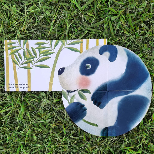 Panda-shaped book page on grass with other page featuring bamboo leaves in the background and greek language text